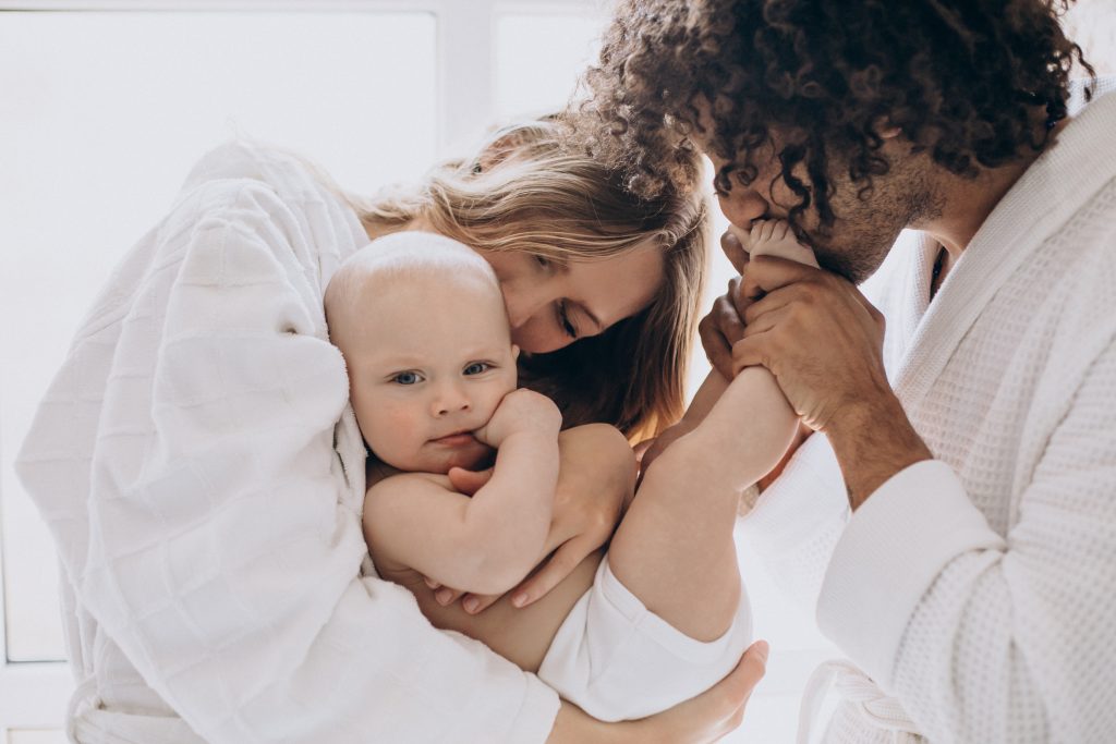 Familia multicultural con su hijo pequeño divirtiéndose juntos.