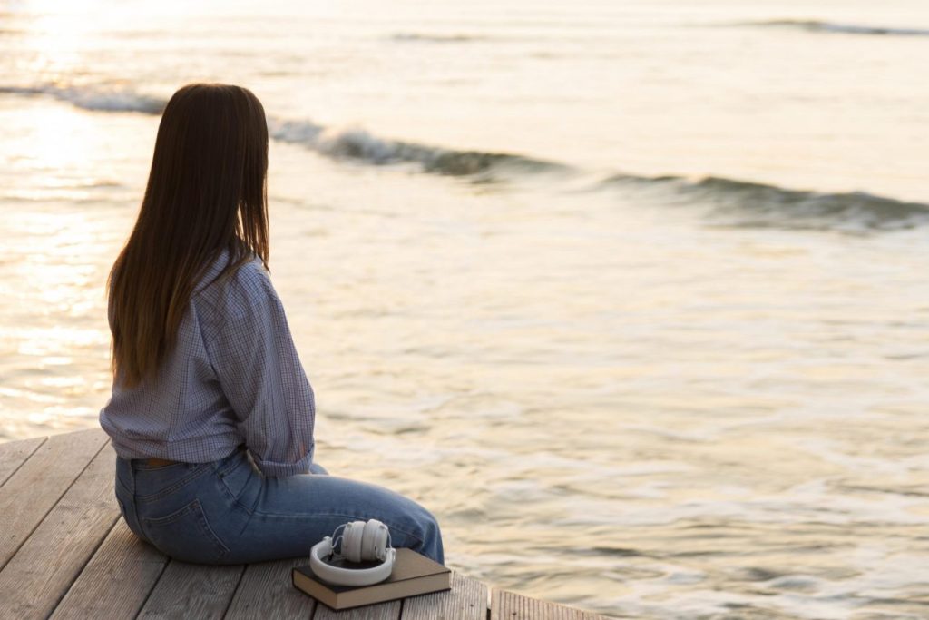 mujer mirando el horizonte en la playa