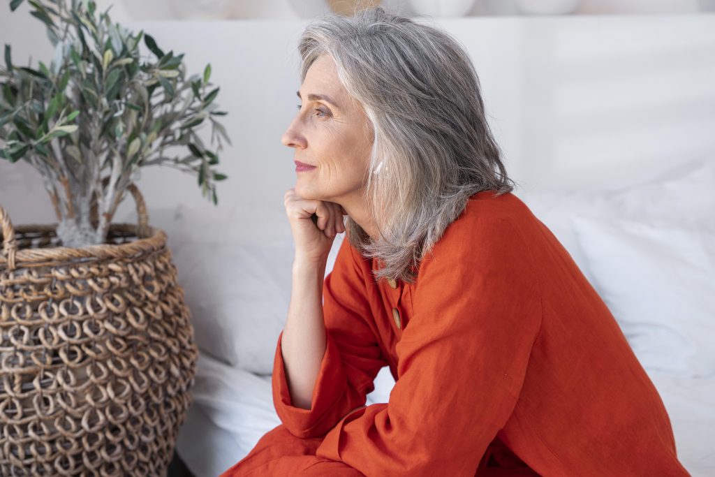 mujer de mediana edad pensativa con blusa roja