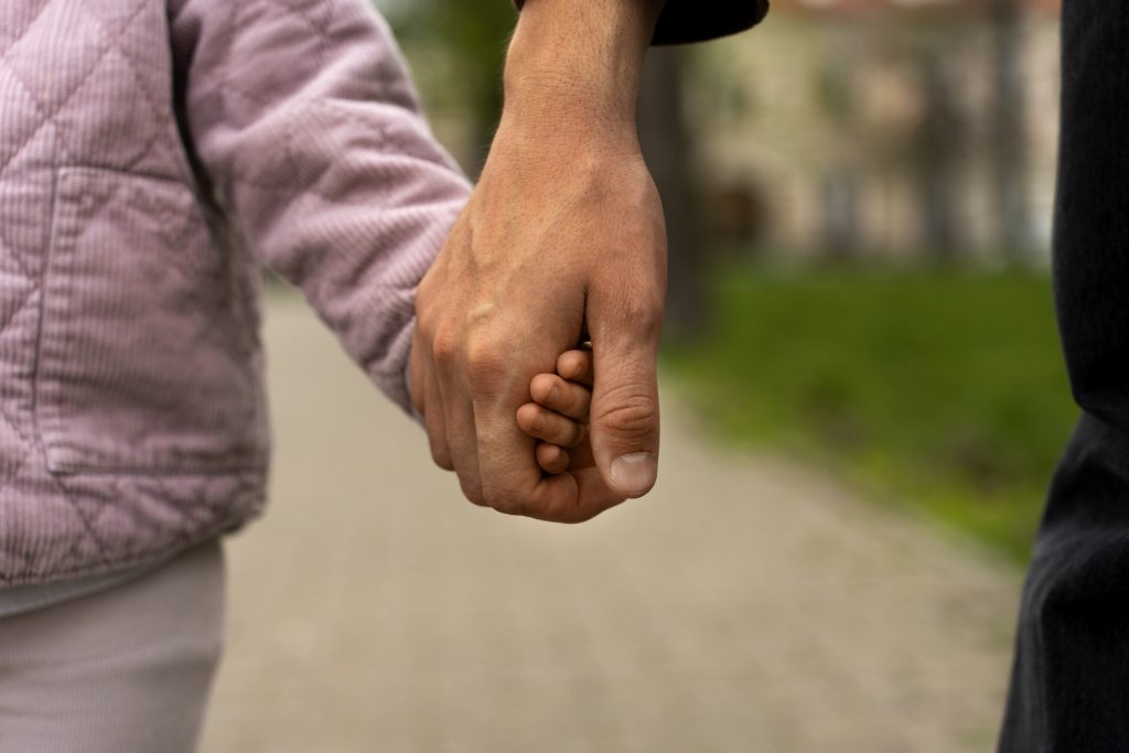padre e hija de la mano caminando